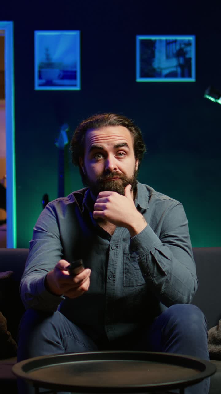 Vertical video Frowning man watching sports match on TV, flabbergasted by goal conceded