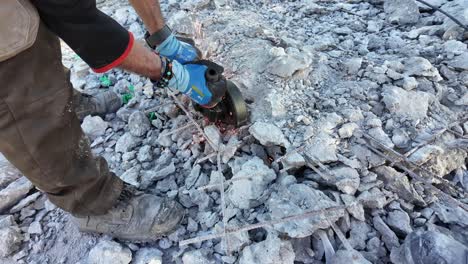 man cutting steel fiber-reinforced concrete's construction iron with a round iron cutting machine,sparks over debris.