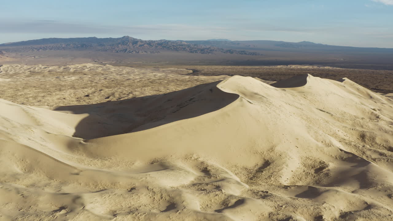 drone volando hacia atrás revelando una gran cadena de dunas de arena en la reserva nacional de mojave