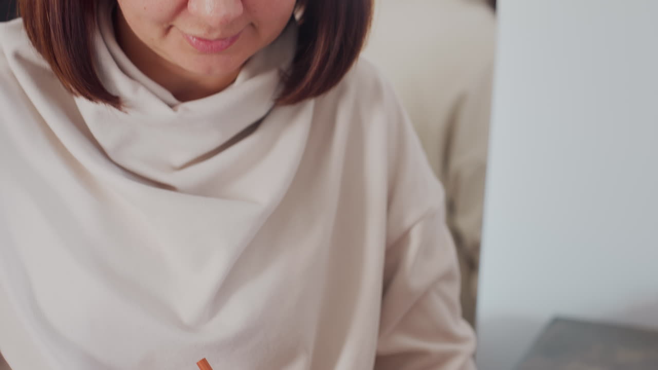 Ladies reviewing jacket design during creative session one woman holding colored pencil while focusing on design details brainstorming and discussing improvements in bright fashion studio