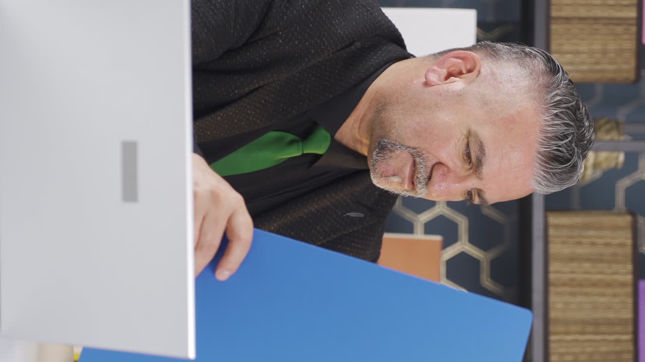 성공적인 사업가가가 서류 파일에서 행복하게 일하는 수직 비디오.