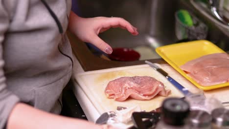 adding various spices on top of filled chicken breast