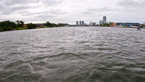 waves on canal with city buildings