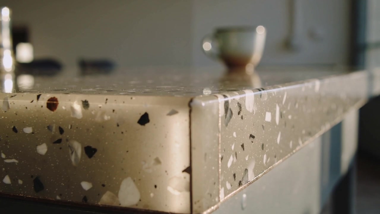 Telecamera in movimento che mostra un angolo di terrazzo che forma una goccia e una striscia di liquido sull'isola della cucina, con una ciotola.