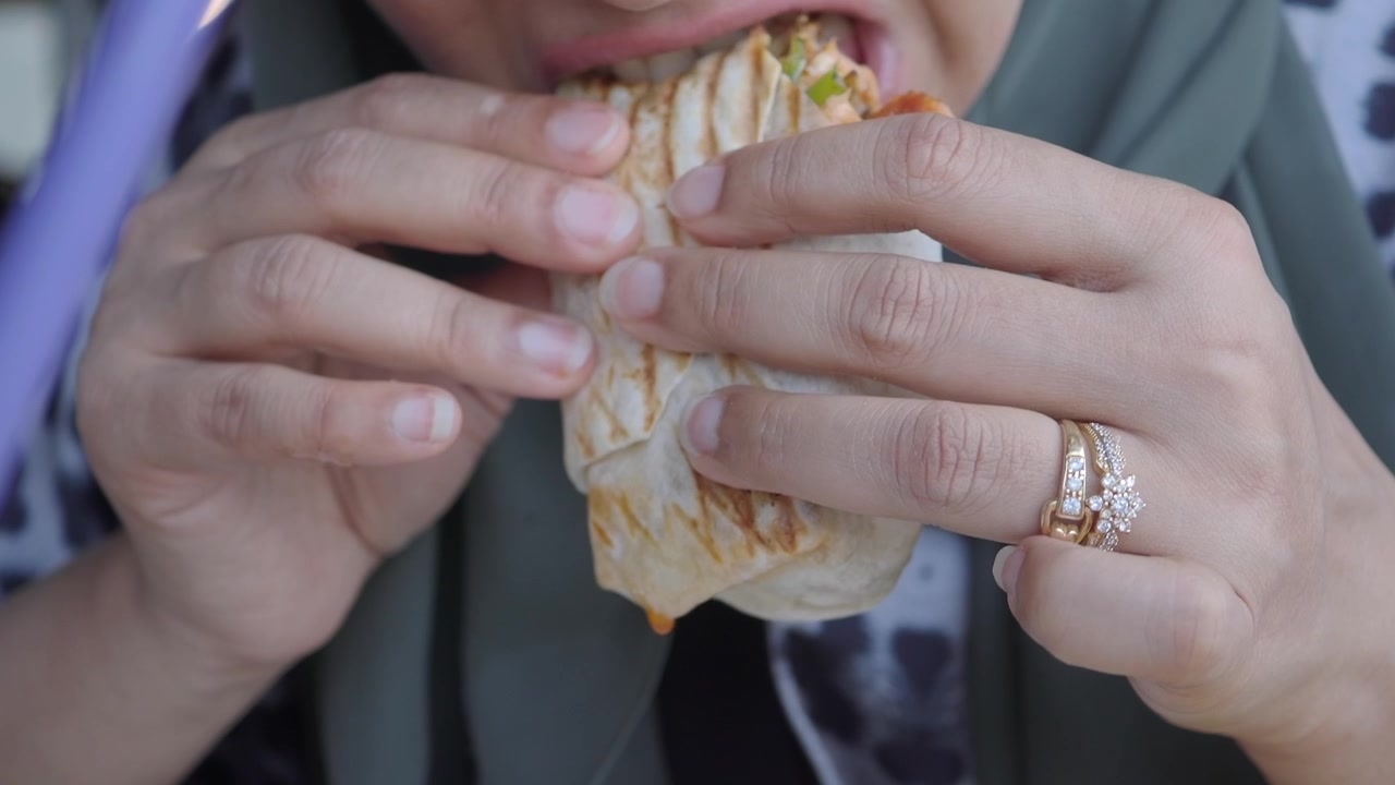 Woman Eating a Grilled Chicken Wrap