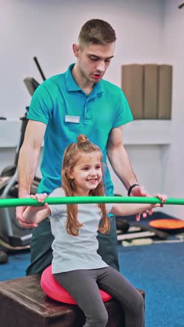 young girl doing exercises under physiotherapist supervision