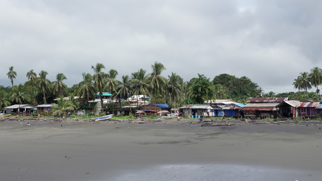 Simple beachfront houses and palms line a fishing village on Colombia’s Pacific coast