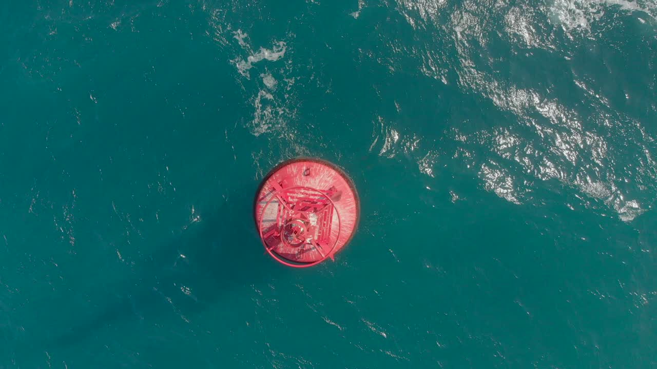 Aerial shot of a red buoy in a beautiful blue sea
