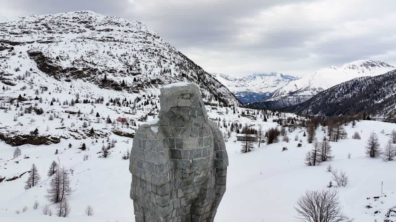 águila escultura de piedra en el paso de simplon con en el fondo los altos alpes suizos cubiertos de nieve