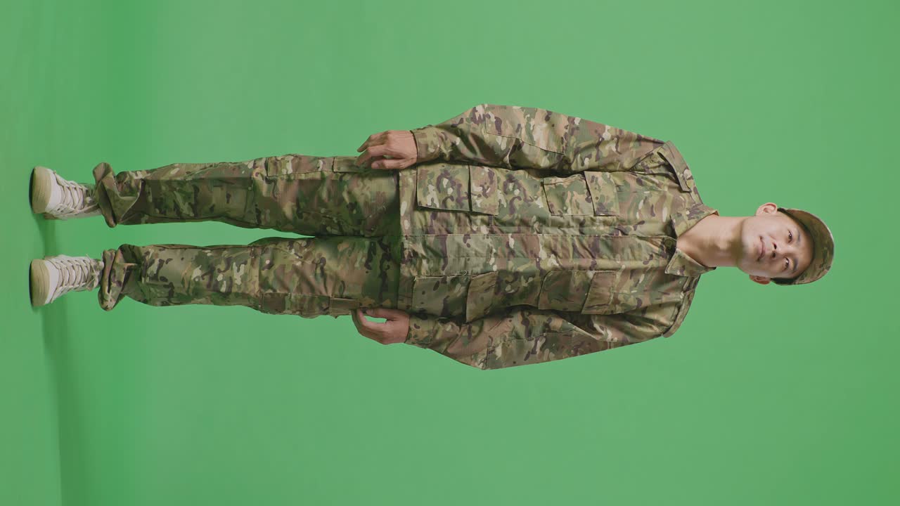 Full Body Of Asian Man Soldier Looking Around While Standing In The Green Screen Background Studio