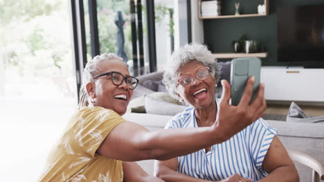 Felices-Amigas-Afroamericanas-Mayores-Tomando-Selfies-Con-Teléfono-En-El-Comedor,-Cámara-Lenta