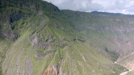 smooth drone shot in panoramic motion, showcasing the full extent of the trekking path to sangalle oasis, highlighting the breathtaking landscape and the winding path through the colca canyon.