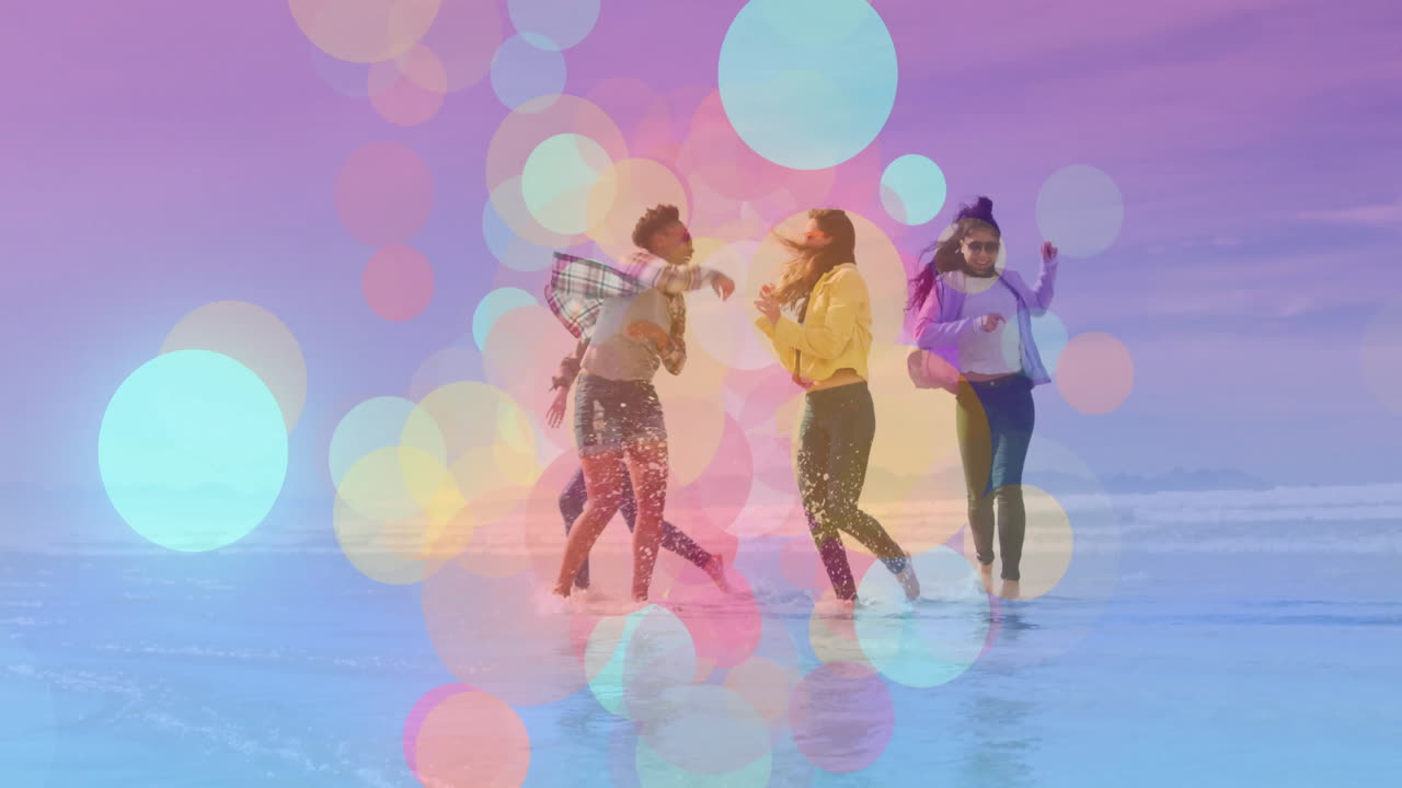 People dancing joyfully on beach with colorful bubble animation overlay