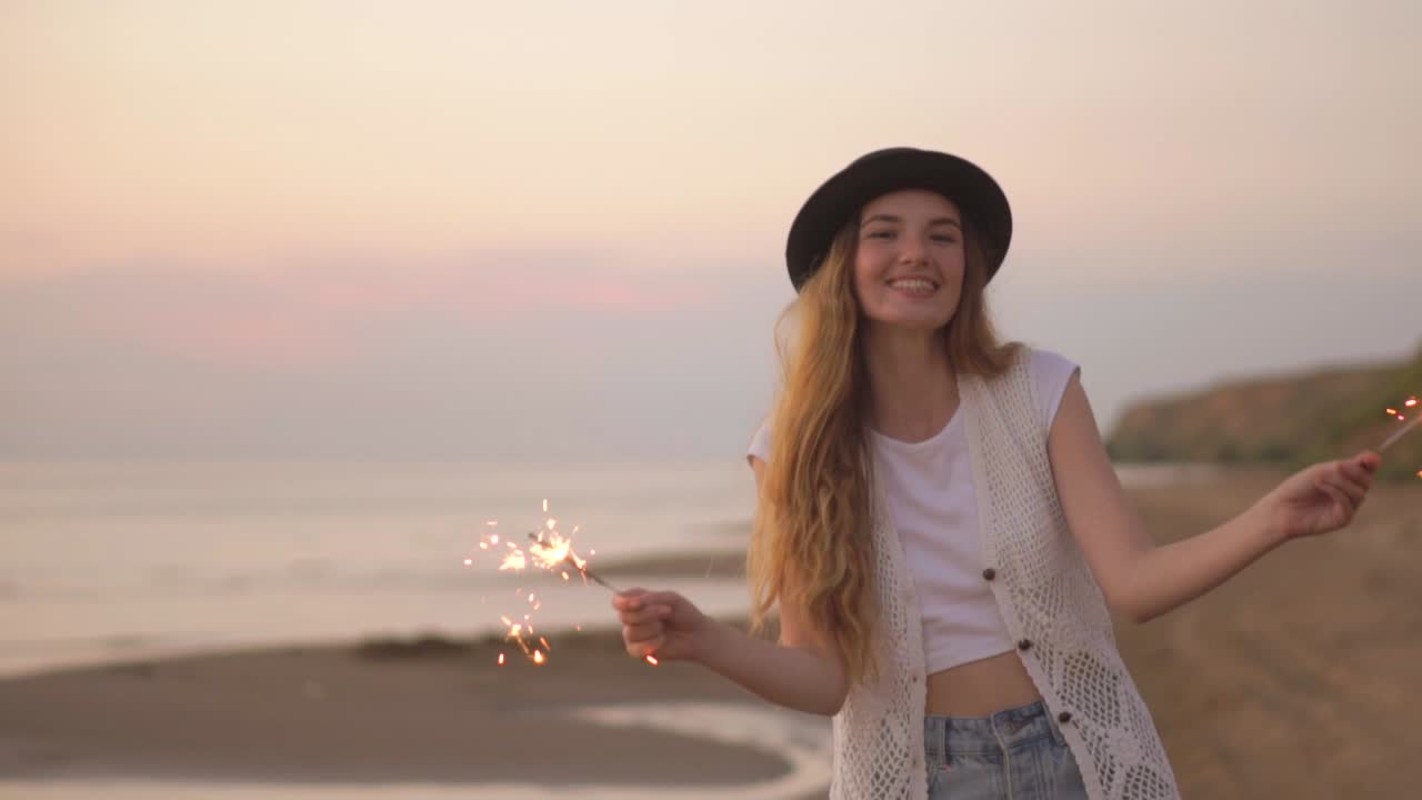 Happy Woman with Sparkler at Sunset Beach