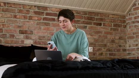 mujer haciendo videollamada en la cama