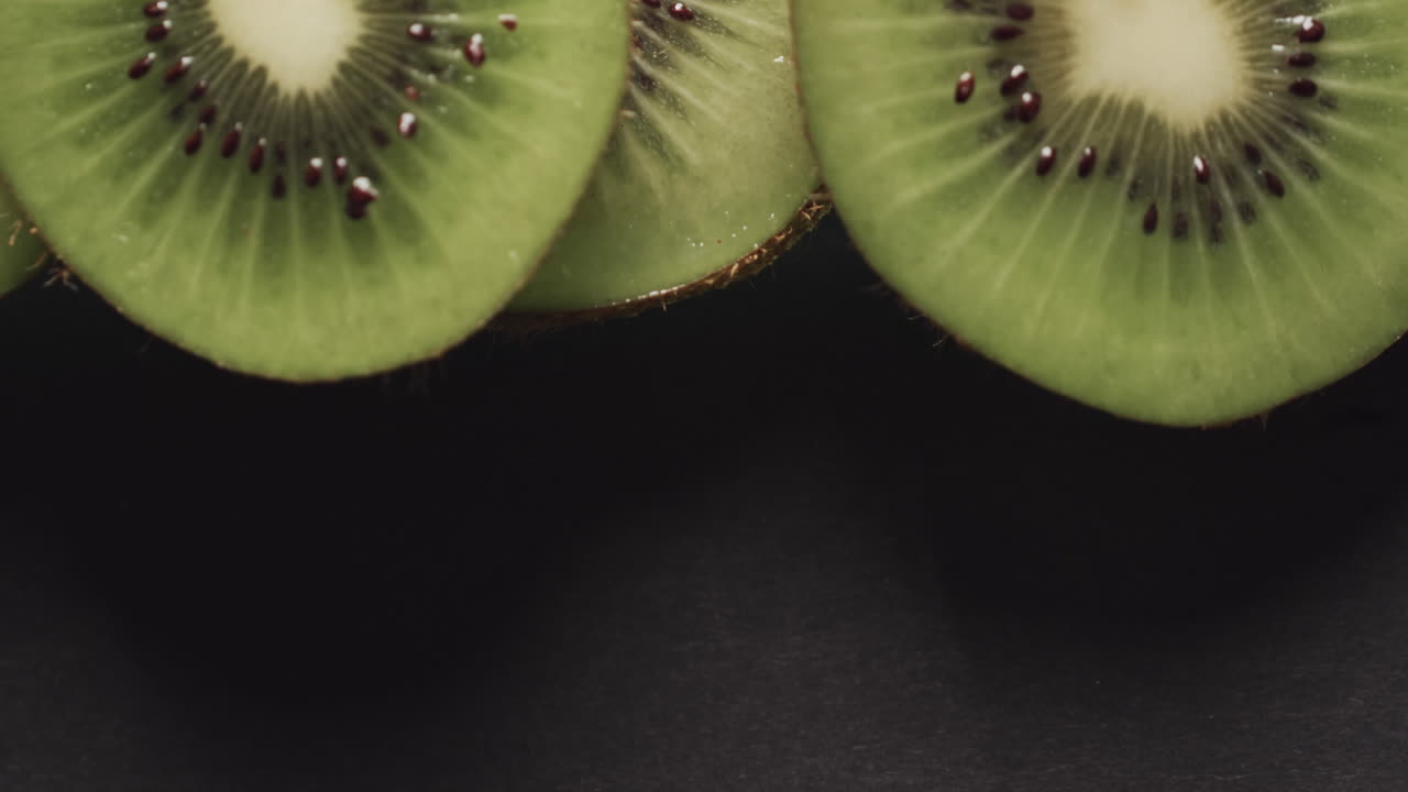 micro vídeo de close-up de fatias de kiwi com espaço de cópia em fundo preto