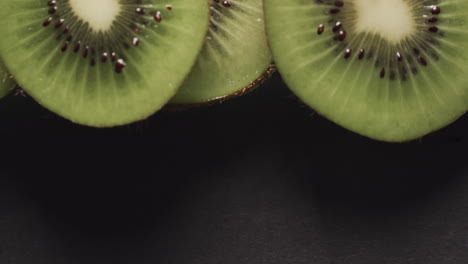micro vídeo de primer plano de rebanadas de fruta de kiwi con espacio de copia en fondo negro