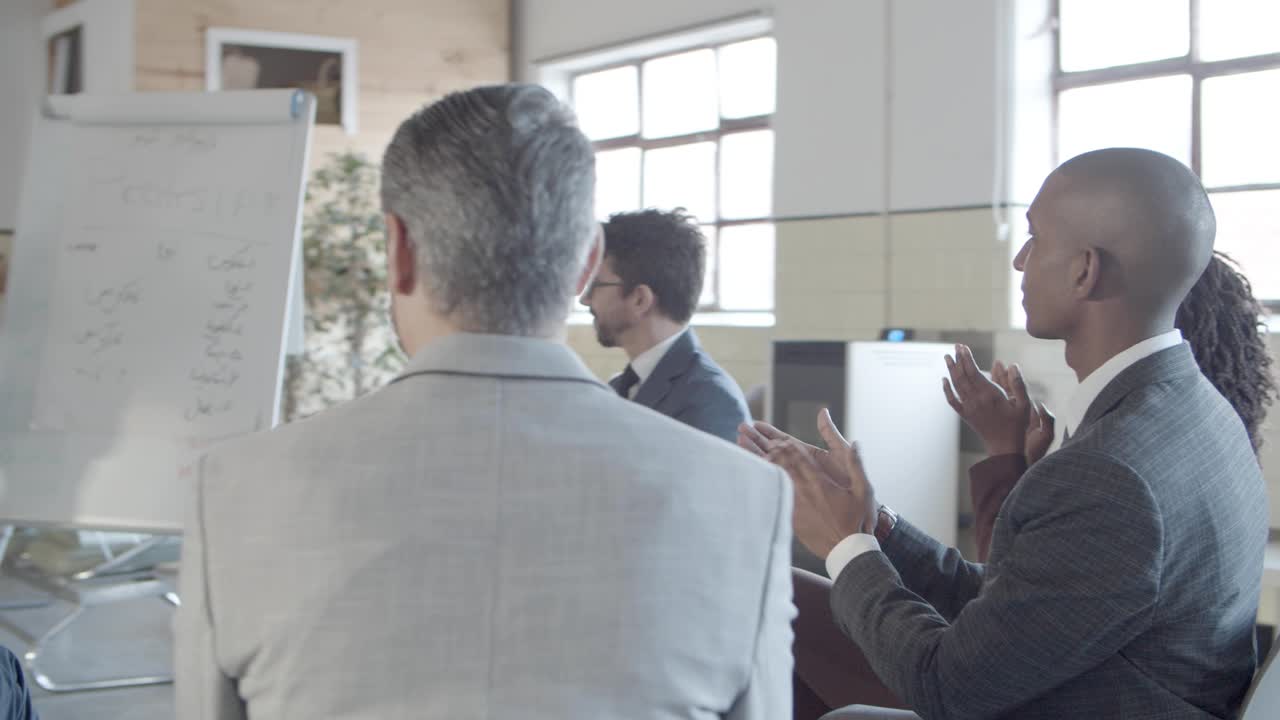 행복 한 동료 들 이 성공적 인 여성 연사 를 박수 를 치고 있다