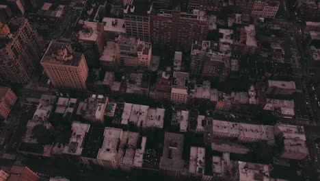 AERIAL:-Overhead-View-of-Skyscraper-Building-Rooftops-in-Manhattan-New-York-City-at-Dawn-after-Sunset