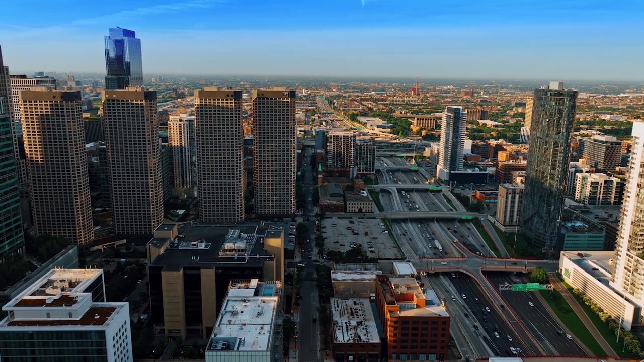 Spostandosi lungo le autostrade a più corsie di Chicago, Illinois, Stati Uniti. Prospettiva aerea sulla metropoli al tramonto.