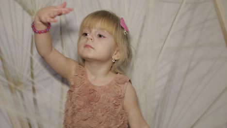 Happy-three-years-old-girl-make-faces-and-dancing.-Cute-blonde-child