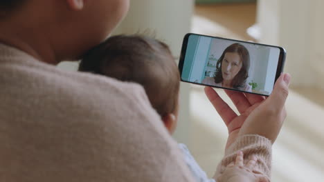 madre joven y bebé chateando por video con la abuela usando un teléfono inteligente saludando a su nieto disfrutando de la conexión familiar hablando por teléfono móvil