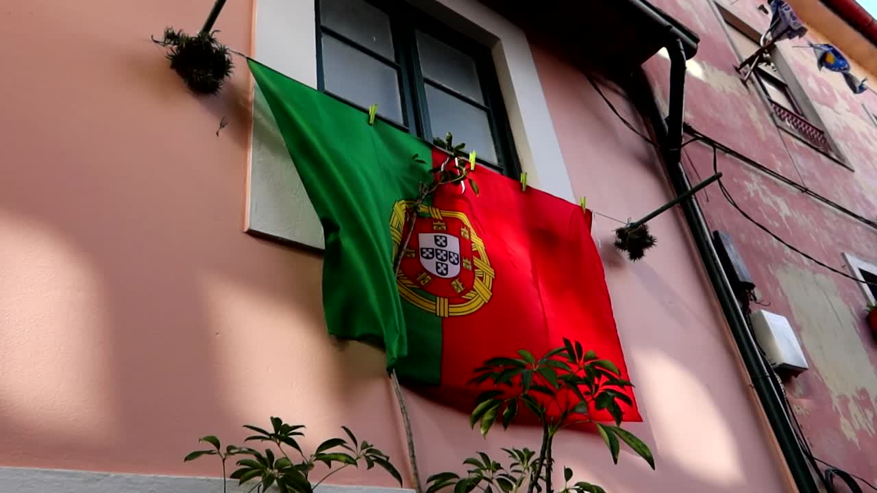 Close-up de Grande Bandeira Portuguesa Pendurada na Janela de uma Casa no Porto, Portugal