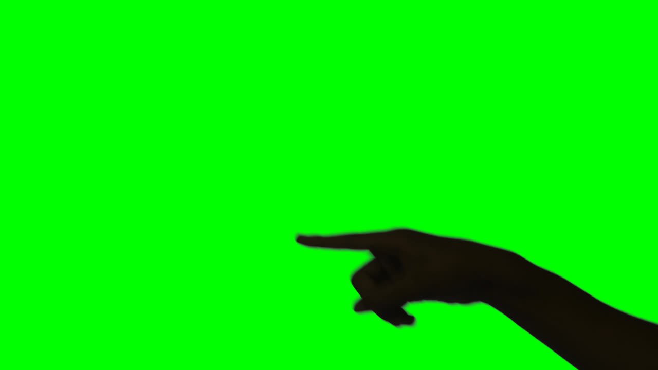 Person making hand gesture against green screen background