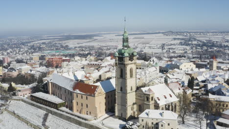 Kleine-Stadt-Am-Flussufer-Mit-Einem-Kirchturm-Im-Winterschnee,-Der-Sich-Dreht