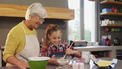 grandmother watching the girl happily while mixing flour 4k 4k