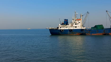 Vista-En-Movimiento-Pasando-Un-Gran-Barco-De-Pesca-Azul-Y-Blanco-En-Las-Aguas-Del-Océano-Atlántico-Frente-A-La-Costa-De-Guinea-Bissau