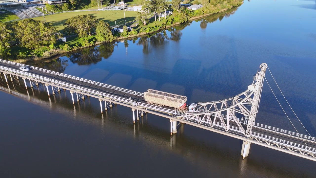 Veduta aerea di un camion e un'auto che attraversano un ponte su un fiume