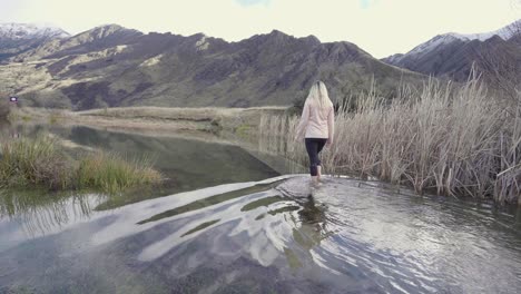 excursionista caminando por aguas poco profundas en el hermoso paisaje de nueva zelanda
