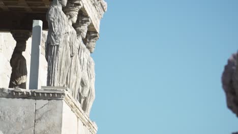 shot of the outer statues of cariátides and acropolis in athens greece