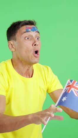 man cheering for australia waving a national flag looking away