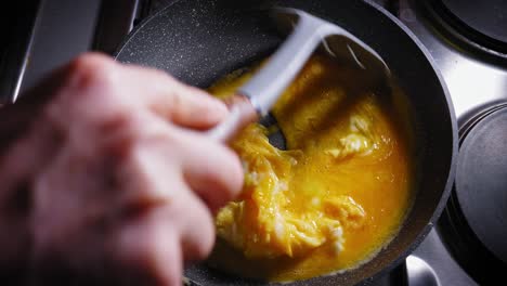 cooking fresh scrambled eggs in a frypan for tortilla dish