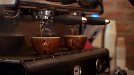 Fresh-expresso-pouring-into-brown-mugs-from-local-coffee-shop,-Close-up-shot