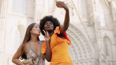 two women taking a selfie in front of a cathedral