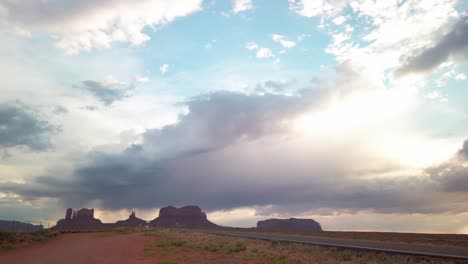 panning shot from sun peeking through clouds to monument valley