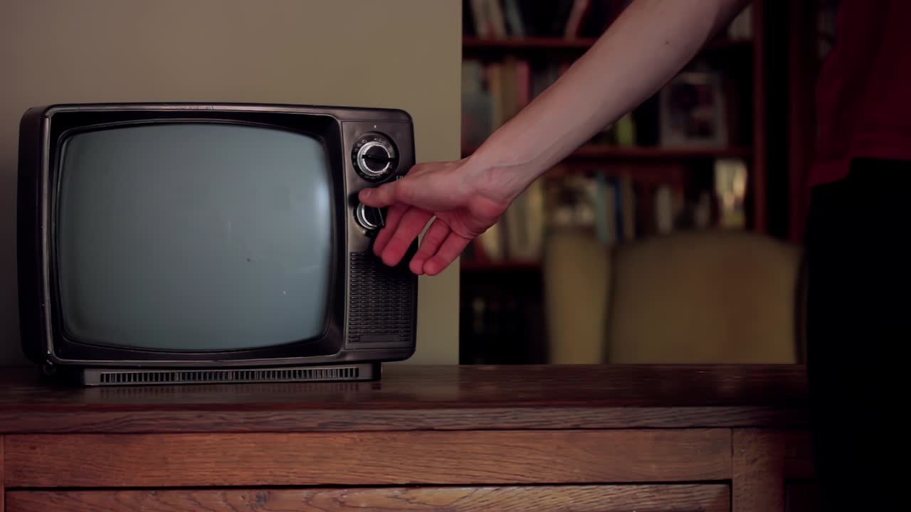 Uomo che colpisce una vecchia TV con schermo verde. Primo piano. Risoluzione 4K