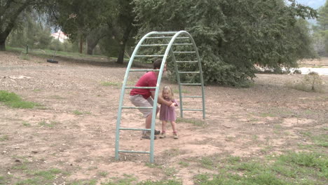 time lapse of a father and daughter playing on a monkey bars in ojai california