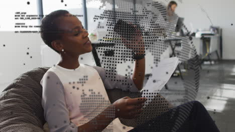 animation of spinning globe, data processing on african american woman reading a document at office