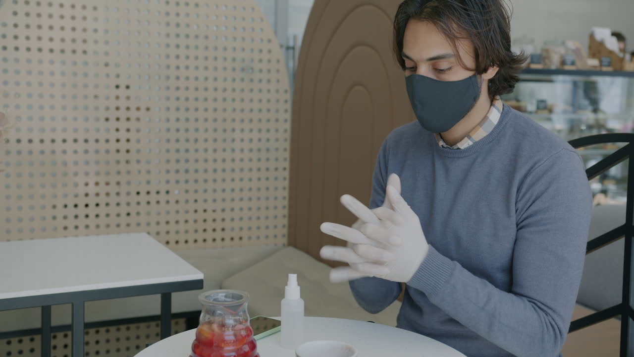 Man wearing a mask and gloves in a cafe