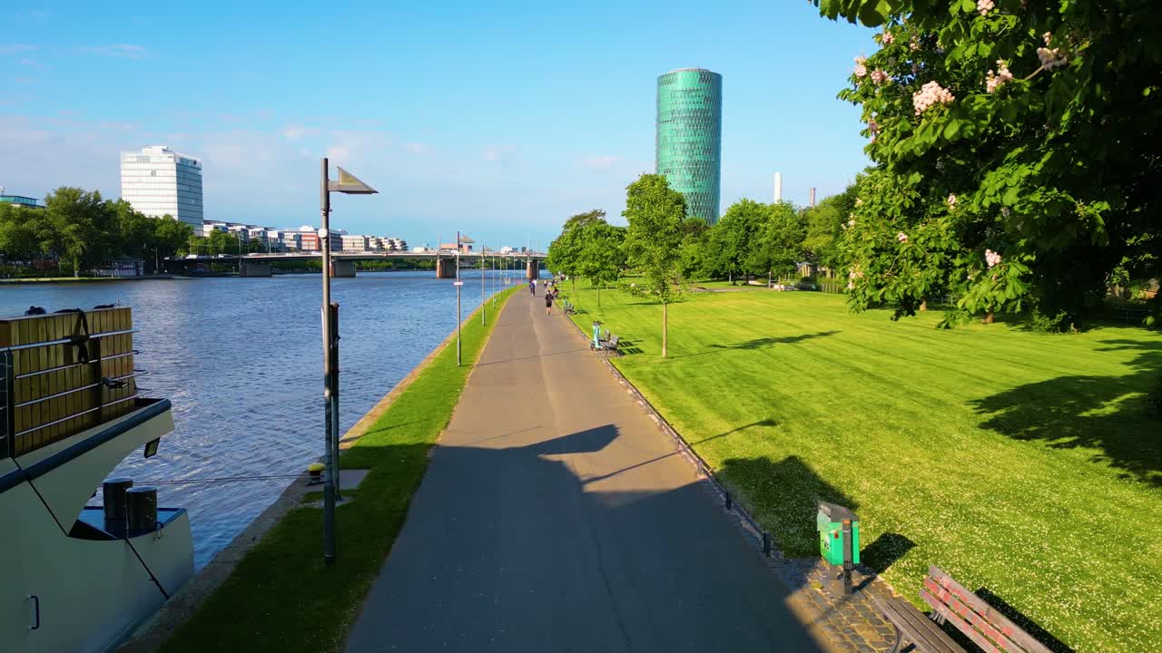 4K Aerial Drone Video of Bicyclist and Jogger on Path along the Main River in Downtown Frankfurt, Germany