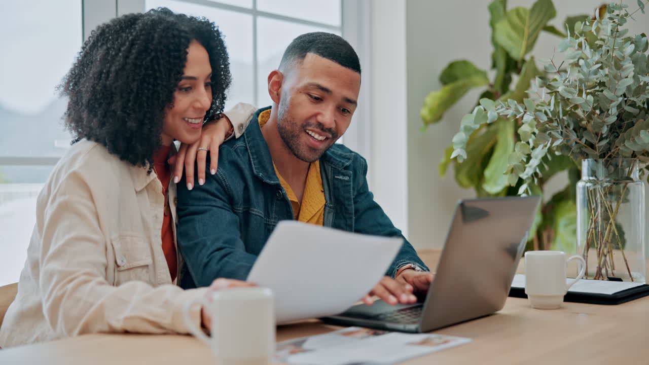 Happy couple working on laptop at home