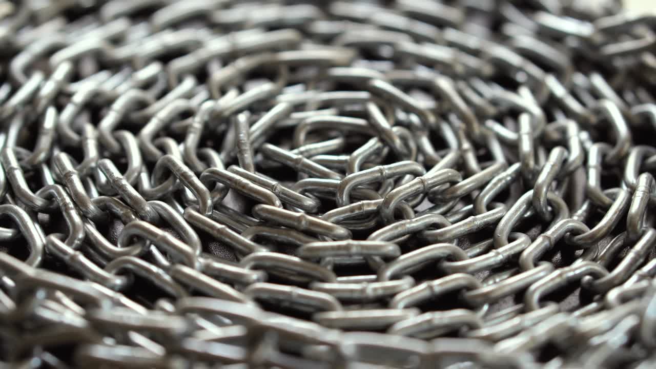 금속 체인은 천천히 회전합니다. 체인 링크는 움직입니다. 산업 배경. 가까이 가십시오.