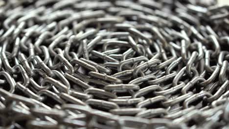 the metal chain slowly rotate. chain links move. industrial background. close up