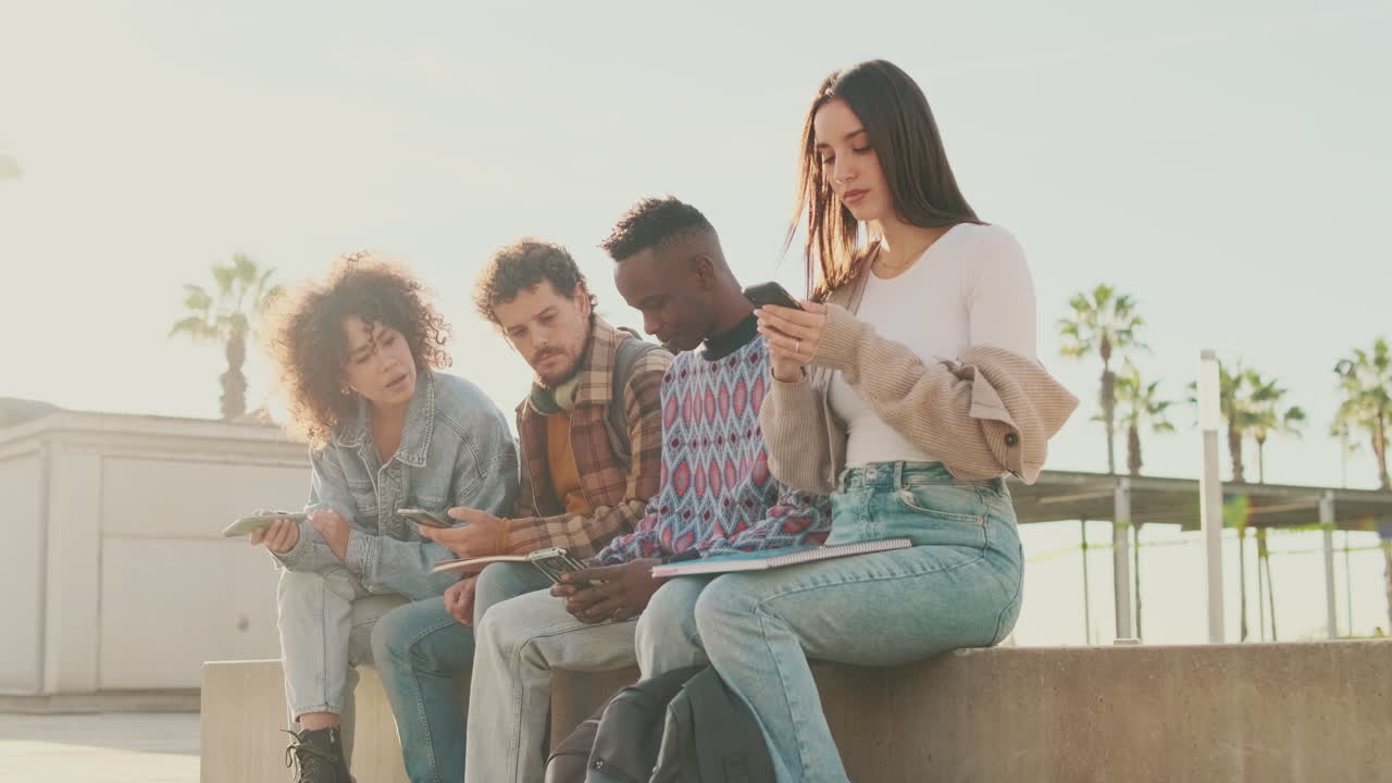 Group of friends using mobile phones outdoors
