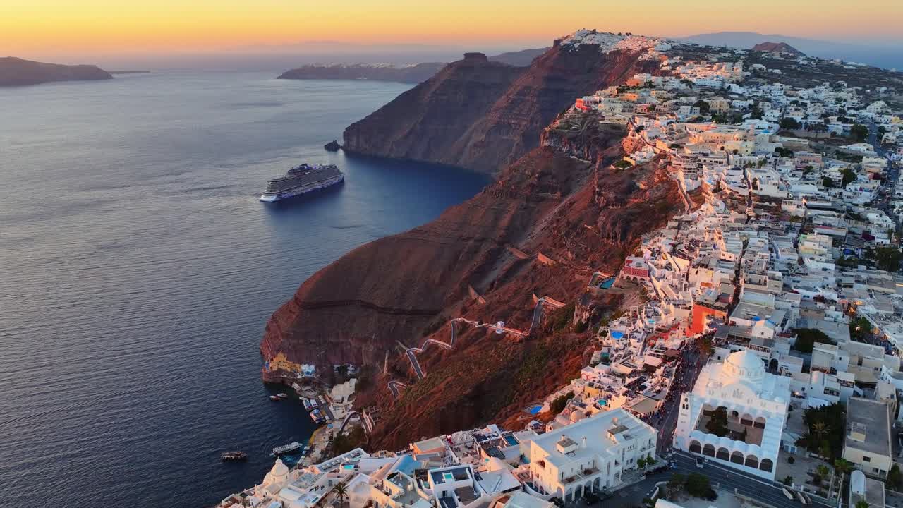 Sunset drone flight over Fira in Santorini, revealing Imerovigli and Oia along the caldera’s dramatic edge in golden light