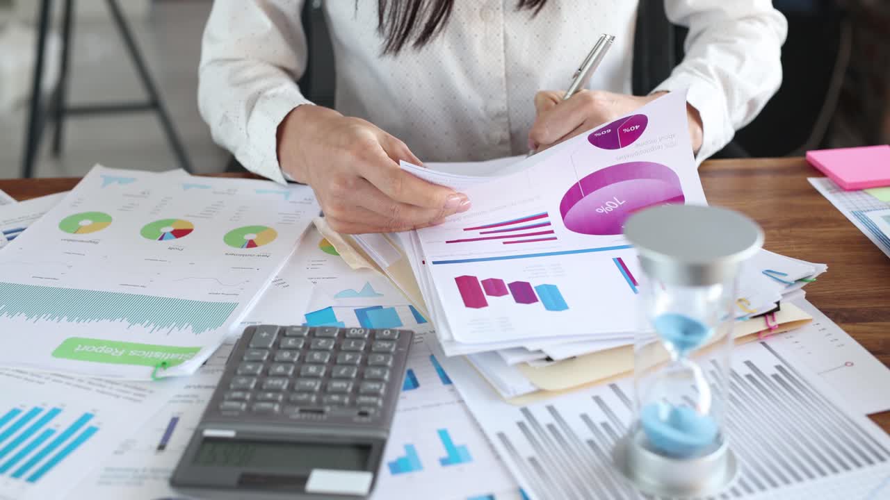 A person analyzing business data and financial reports on an office desk